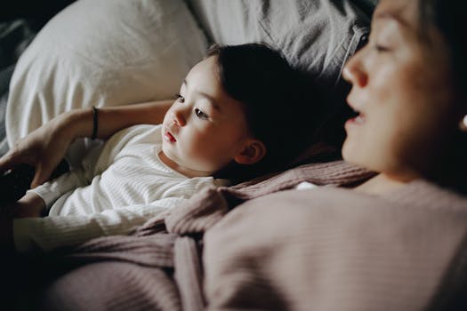 A mother and child bonding and relaxing on a cozy bed indoors, creating a warm family moment.